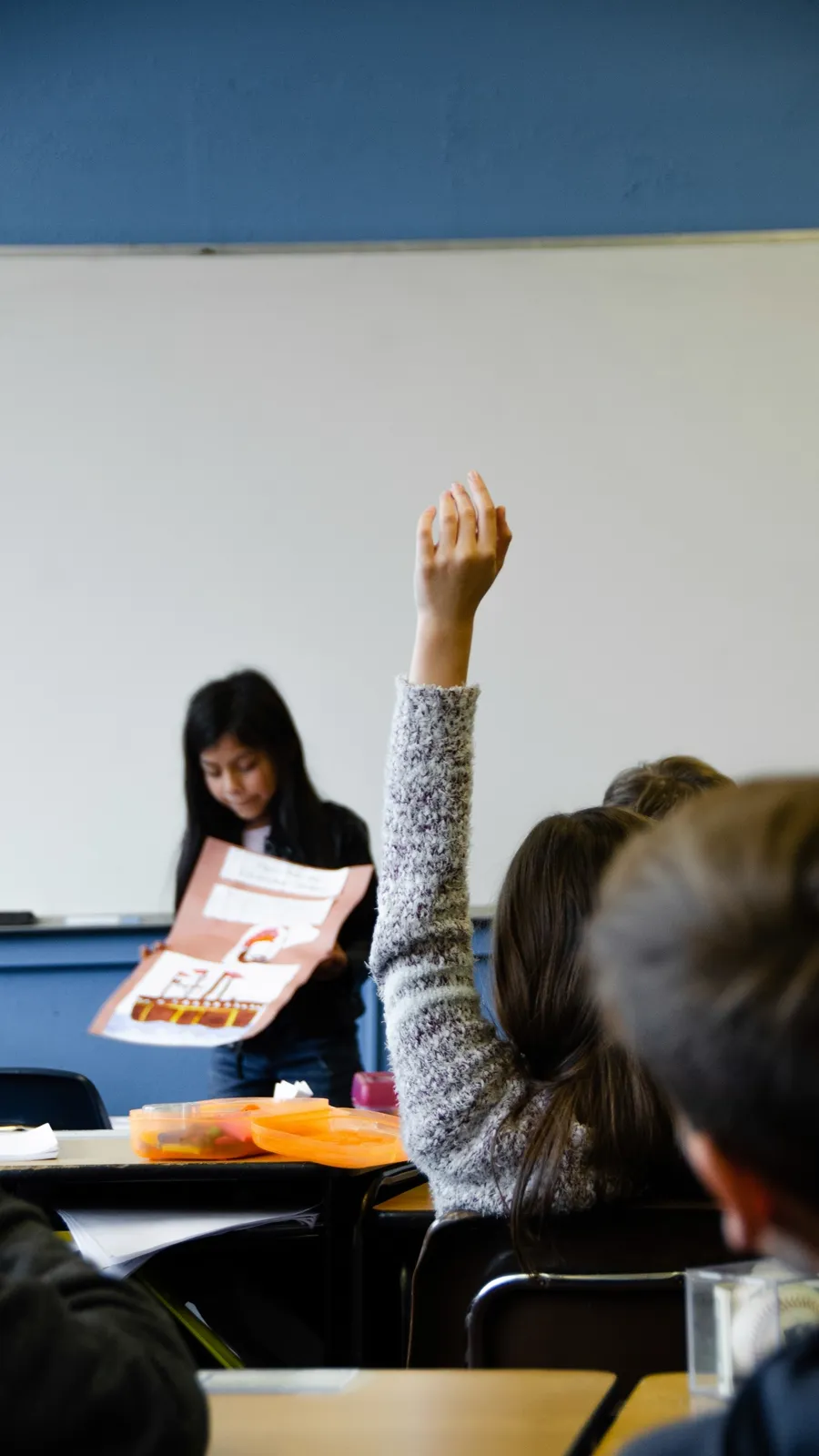 Una estudiante levanta la mano en clase